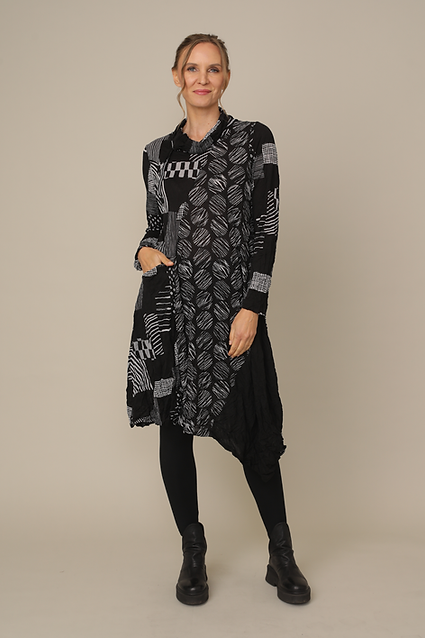 Woman wearing a black and white patterned dress against a beige background