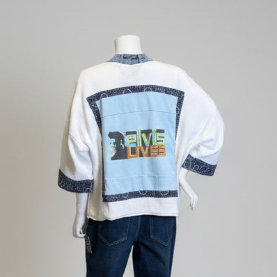 White sweater with colorful text and graphic on a mannequin against a gray background