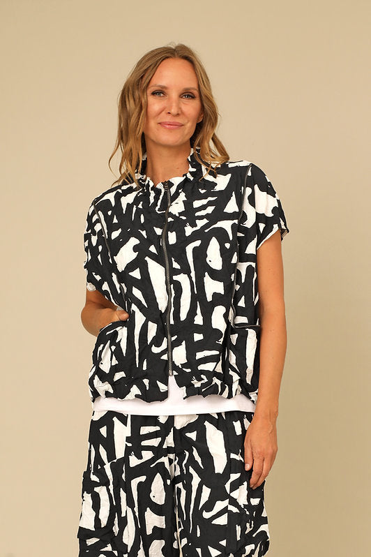 Woman wearing a black and white patterned dress against a beige background. Shop women's clothing and wearable art at Victoria Susan in Camden SC