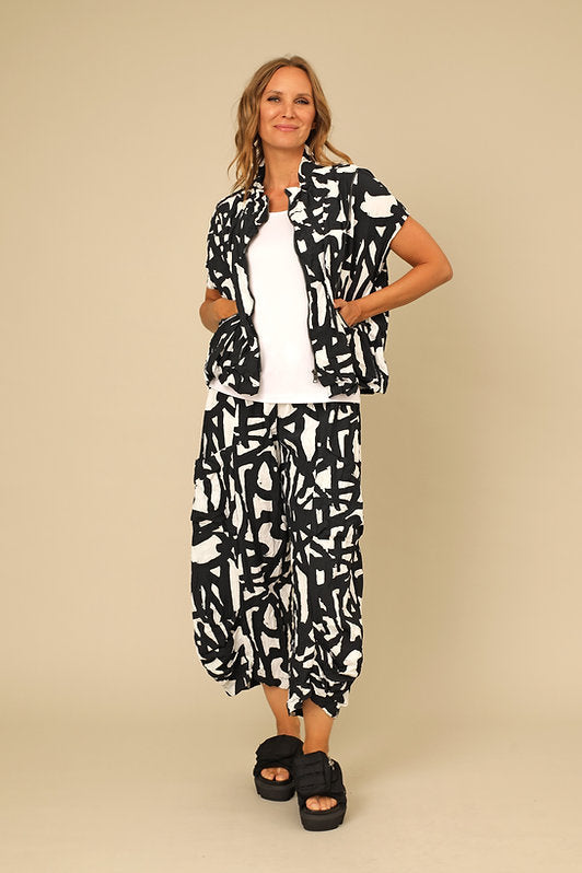 Woman wearing a black and white patterned outfit on a beige background. Shop women's clothing and wearable art at Victoria Susan in Camden SC