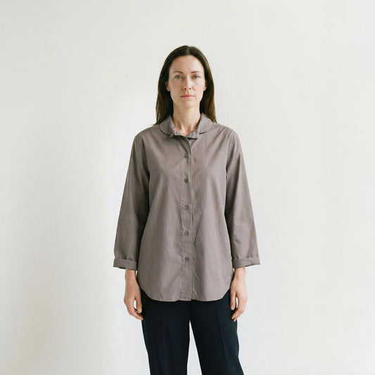 Woman wearing a gray shirt against a plain background