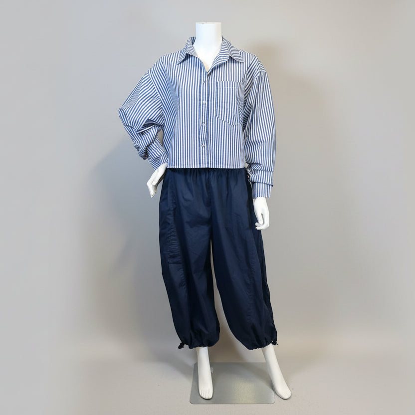 Mannequin wearing a blue and white striped shirt and black pants against a beige background at Victoria Susan in Camden, SC