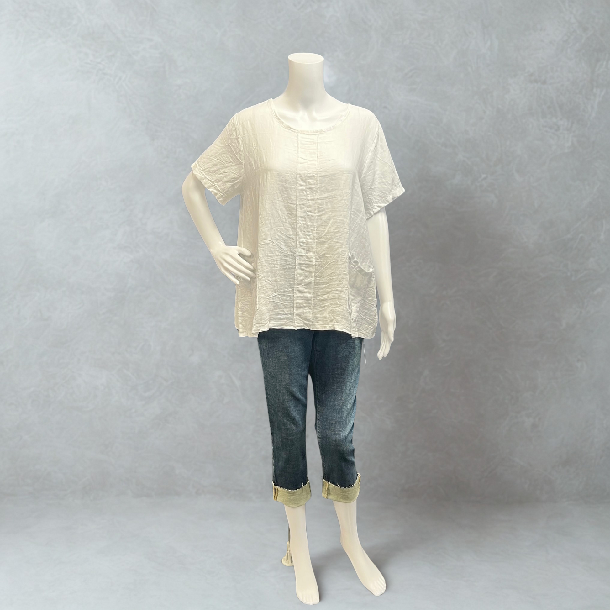 Mannequin wearing a beige top and blue jeans against a gray background