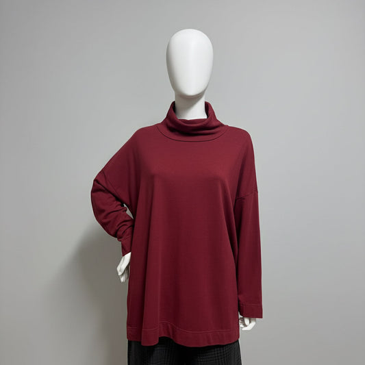 Maroon long-sleeve top on a mannequin against a beige background