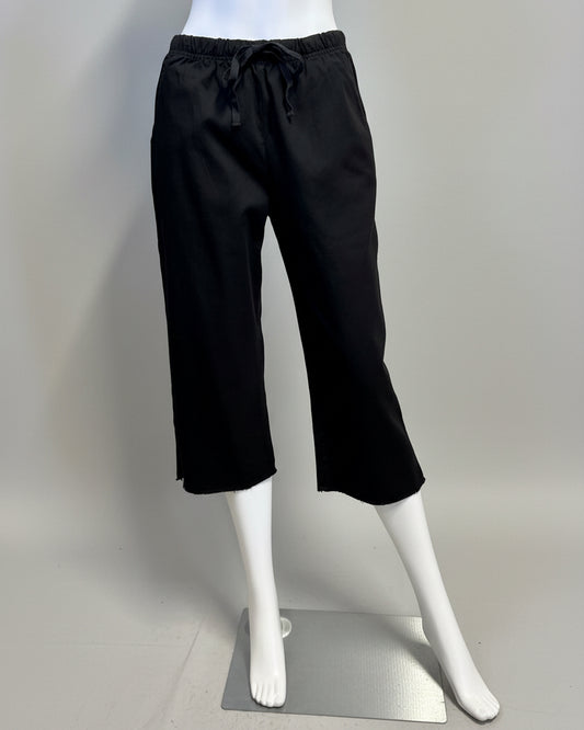 Black pants on a mannequin against a beige background