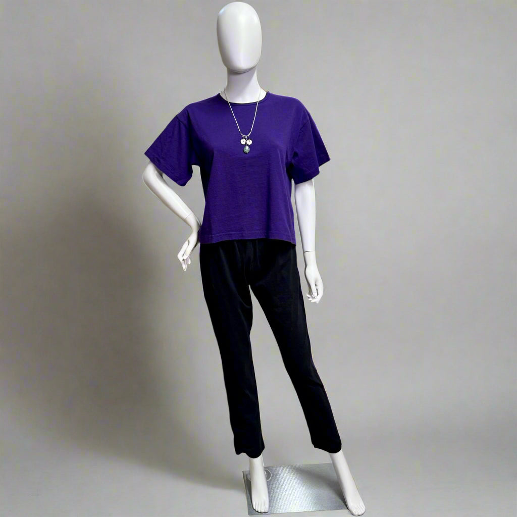 Mannequin wearing a purple shirt and black pants on a gray background. Shop women's clothing at Victoria Susan in Camden SC for great USA made shirts like this. 