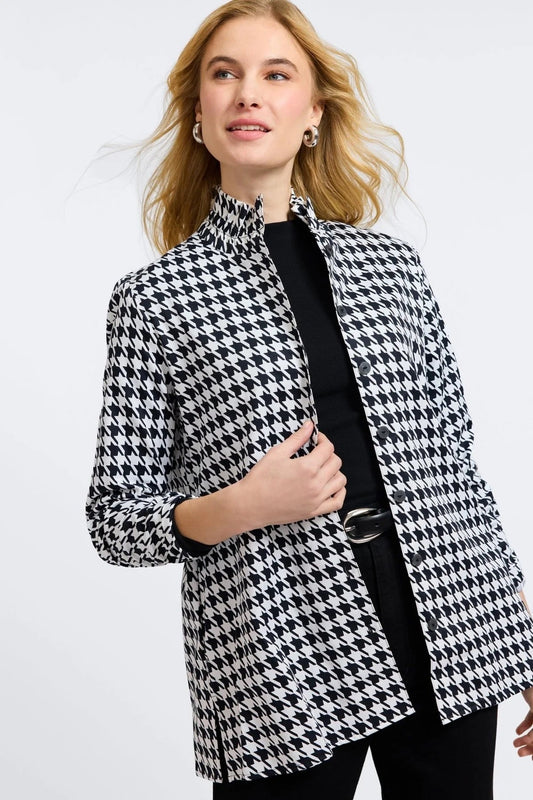 Woman wearing a black and white houndstooth patterned coat by Foxcroft  on a light gray background at Victoria Susan Wearable Art in Camden SC.