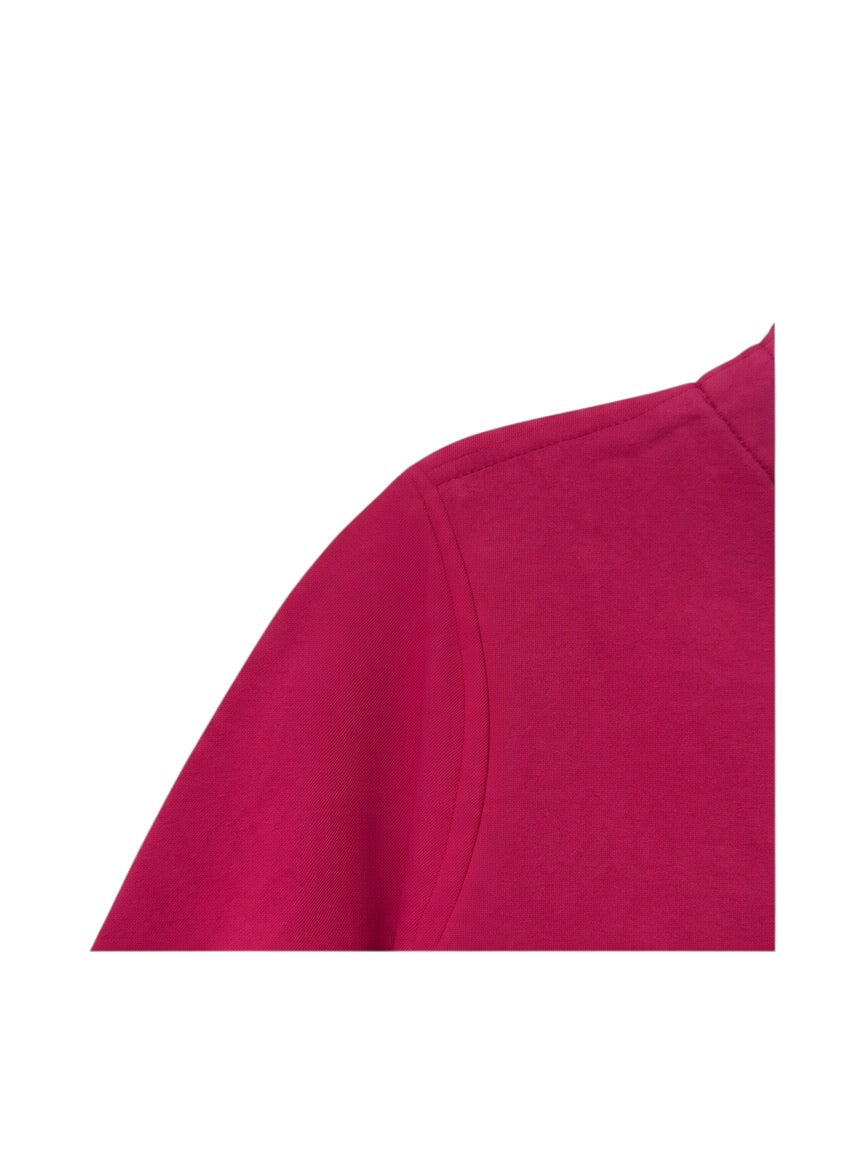 A close-up of a bright magenta pink fabric, showing the shoulder seam and collar area of a garment, isolated on a white background.