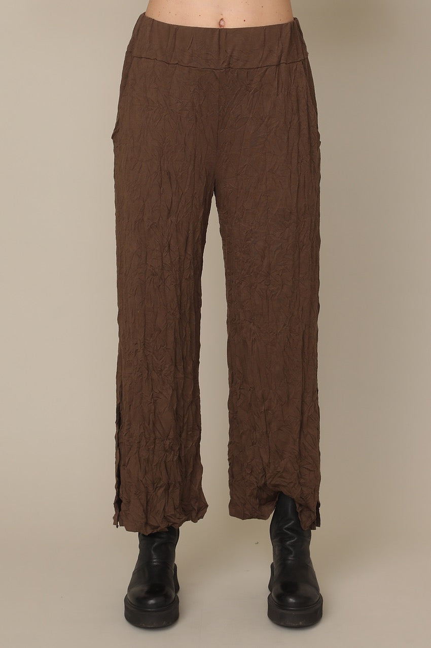 Brown textured pants worn by a person on a beige background at Victoria Susan Wearable Art in Camden SC