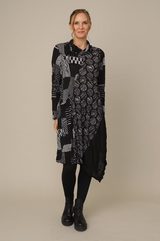 Woman wearing a long, patterned black and gray scarf against a beige background
