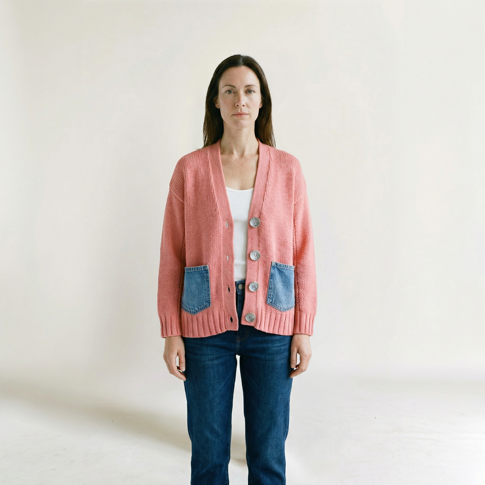 Woman wearing a pink cardigan  by Shannon Passero with blue pocket flaps on a plain background at Victoria Susan in Camden SC 