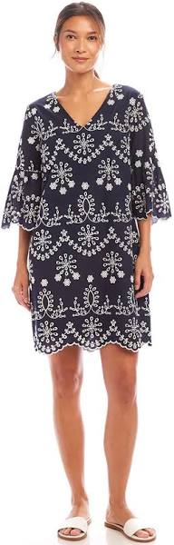Woman wearing a navy blue dress with white floral patterns on a white background