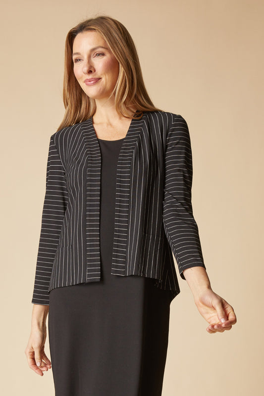 Woman wearing a black and white striped blazer on a beige background